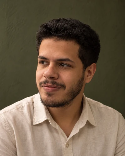 Youssef looking toward the biography in a cream linen shirt